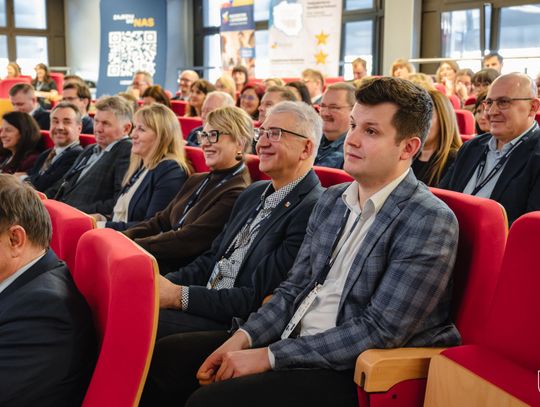 Uczestnicy konferencji siedzą w fotelach