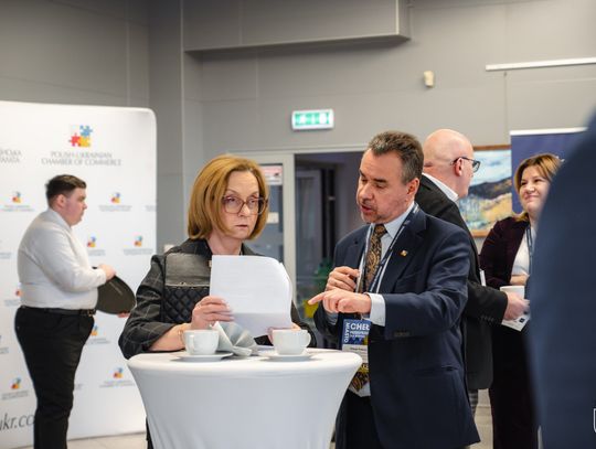 Dwie osoby rozmawiają przy wysokim stoliku