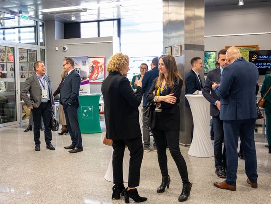 Grupa osób rozmawia w sali