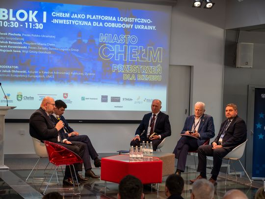 Grupa osób rozmawia na scenie.