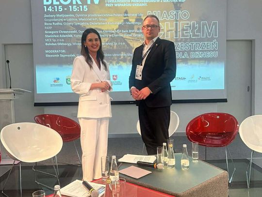 Dwie osoby stoją na scenie.