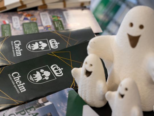 Figurki duchów. W tle ulotki z napisem Chełm Miasto wielu opowieści