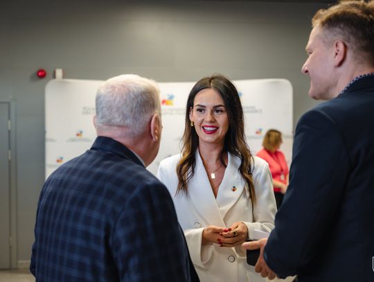 W tle kobieta rozmawiająca z dwoma mężczyznami